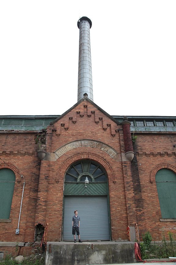 Exterior shot of old power plant before restoration with model standing in front