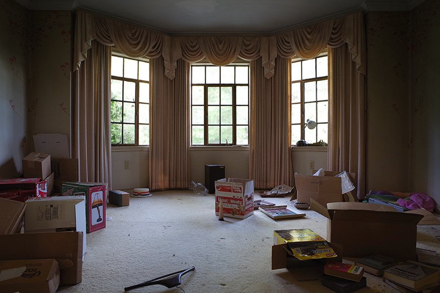 another abandoned room with lots of boxes and bay window