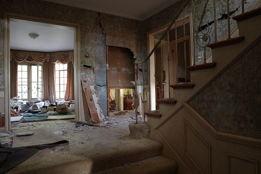 cluttered hallway with destroyed walls and stairs