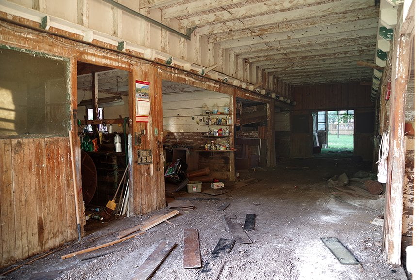 interior of old barn showing stables on both sides
