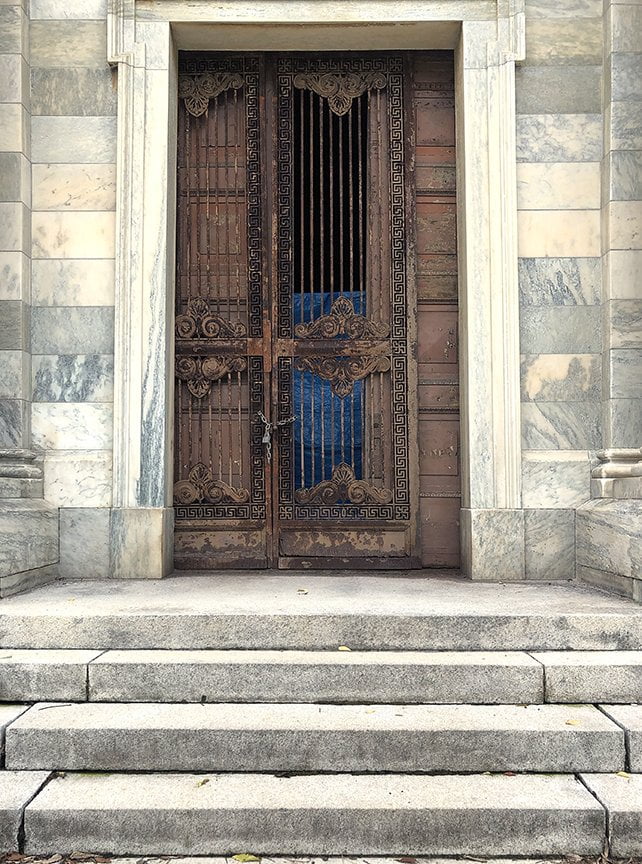 aged metal grilled door with marble surrounding it