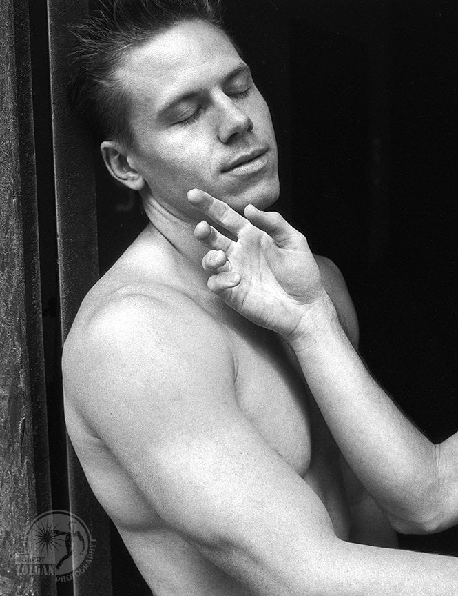 shirtless man with eyes closed as hand from another gently caresses his face