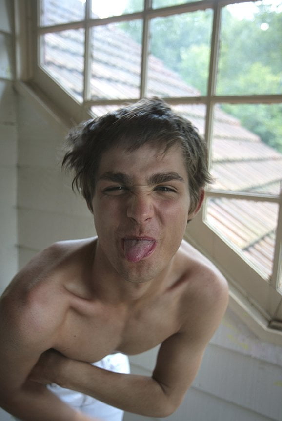 shirtless man sticking tongue out at photographer