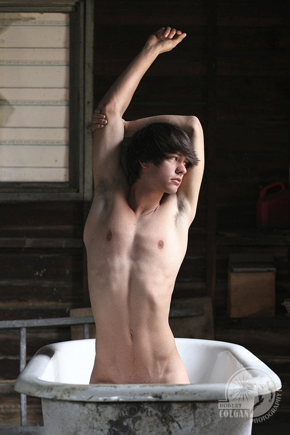partially nude man stretching out of old ceramic tub
