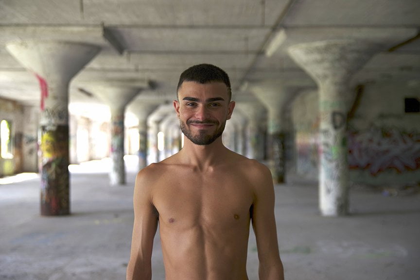 shirtless man smiling at camera