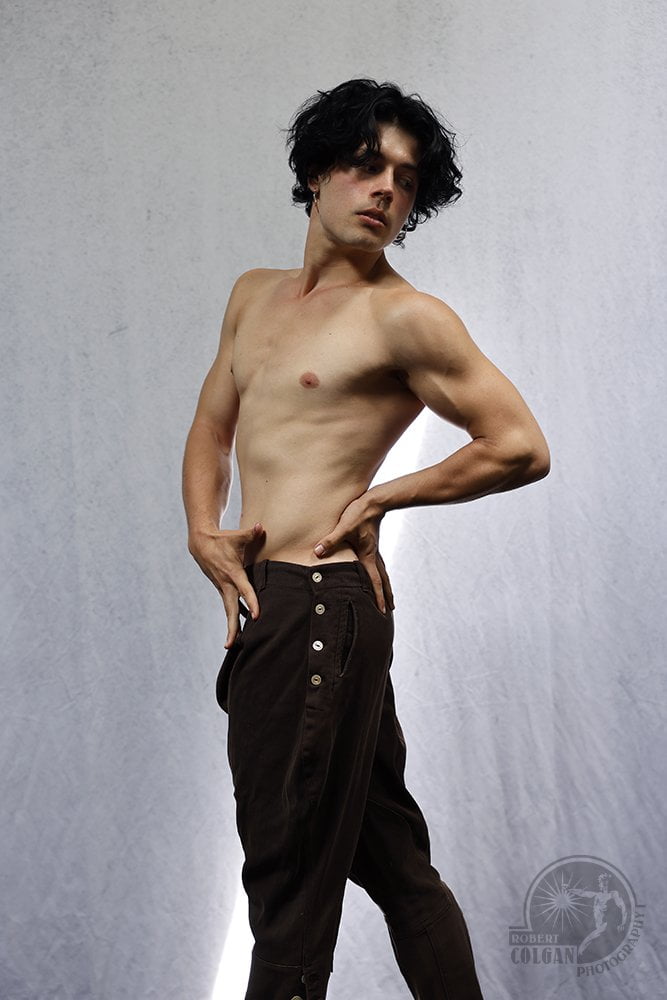 shirtless man twisting his body and looking back