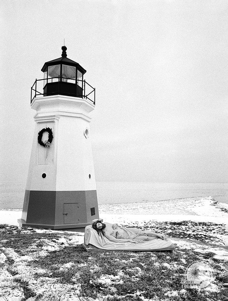 statue of Jesus by lighthouse