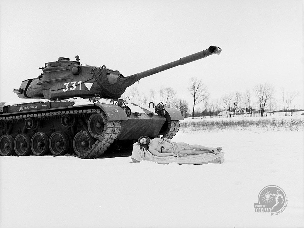 statue of Jesus in the snow near a tank