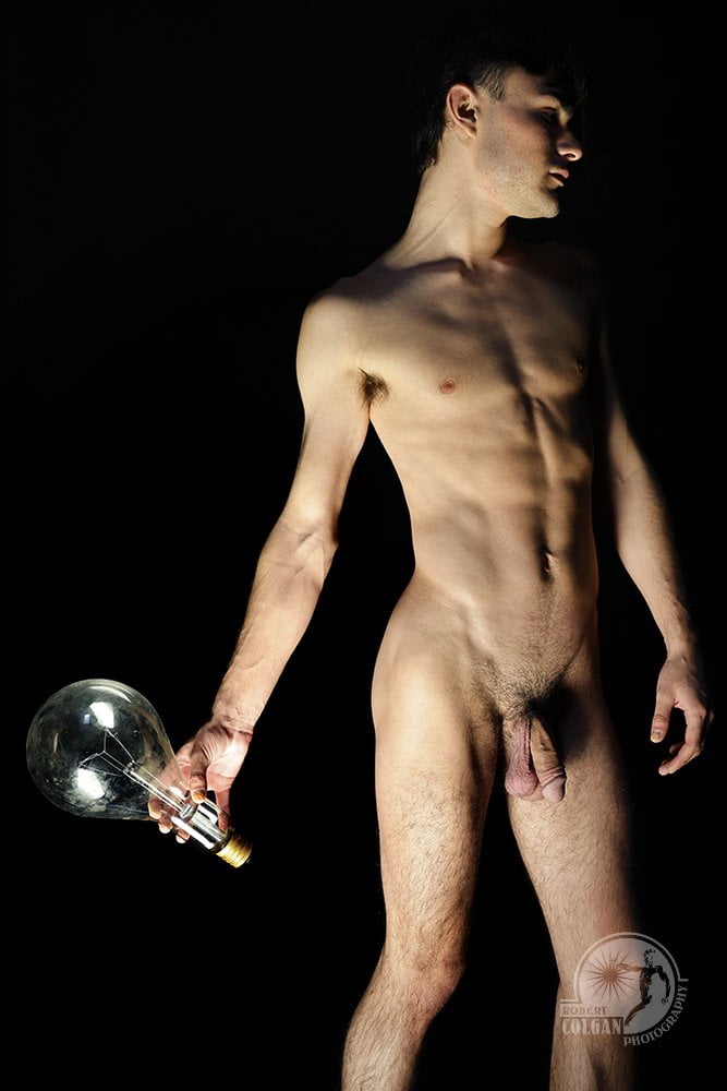 nude man looking away while holding lightbulb