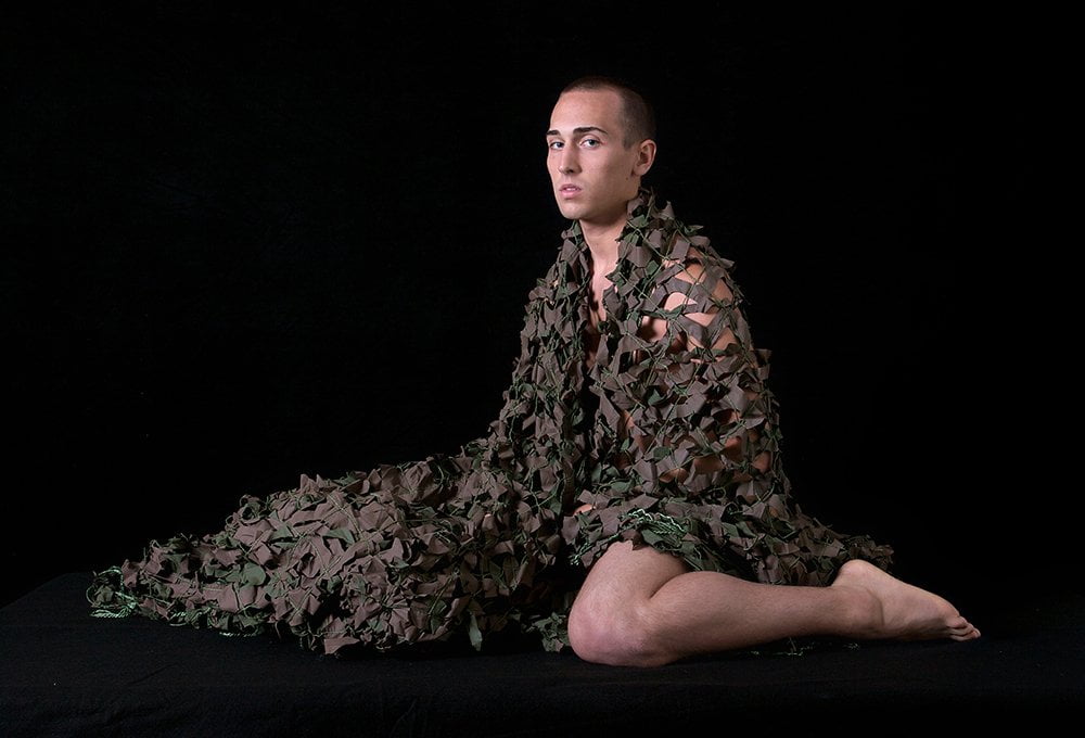 nude man wrapped in camouflage netting