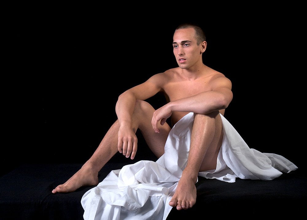 seated nude man with white sheet in lap