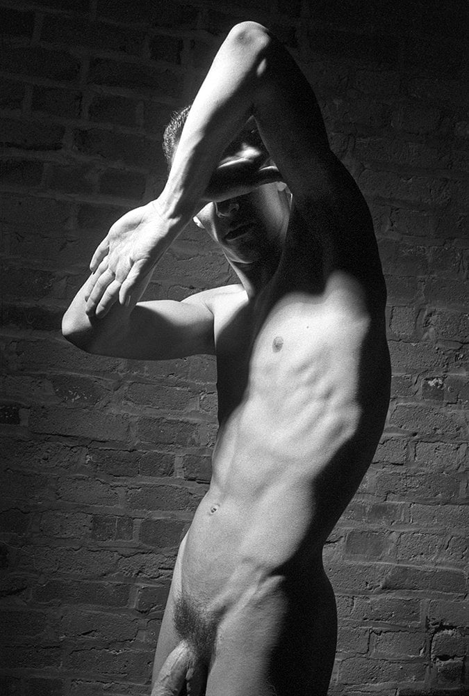 nude male with arms in front of face