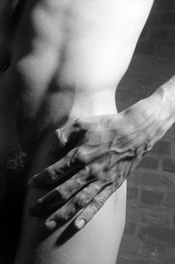close up of hand on nude man's hip