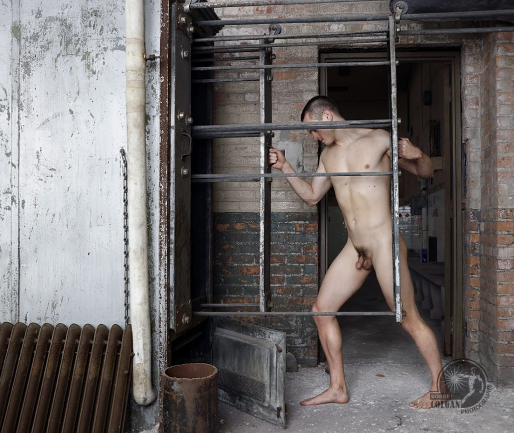 nude man adjusting old machinery in abandoned school