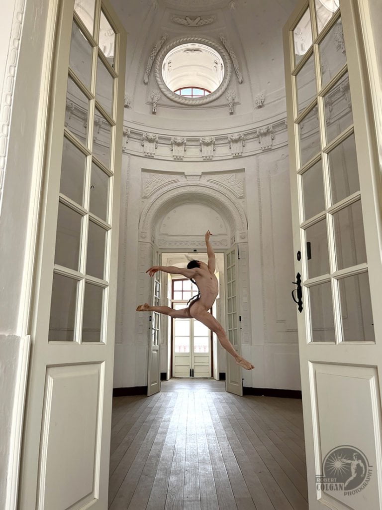 nude man dancing in empty white room