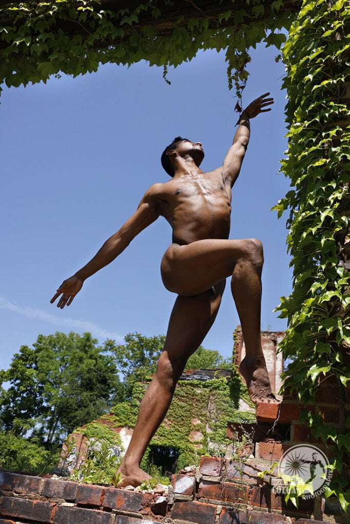 nude man creates dance move in ivy-coated window opening