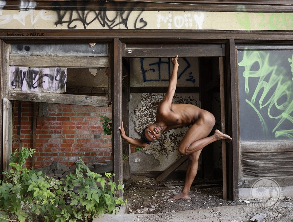 nude man curled up in opening at old school