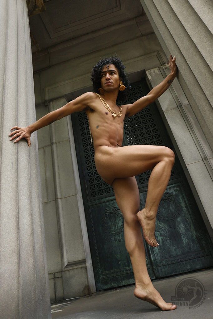 nude man strikes a pose in front on classic structure