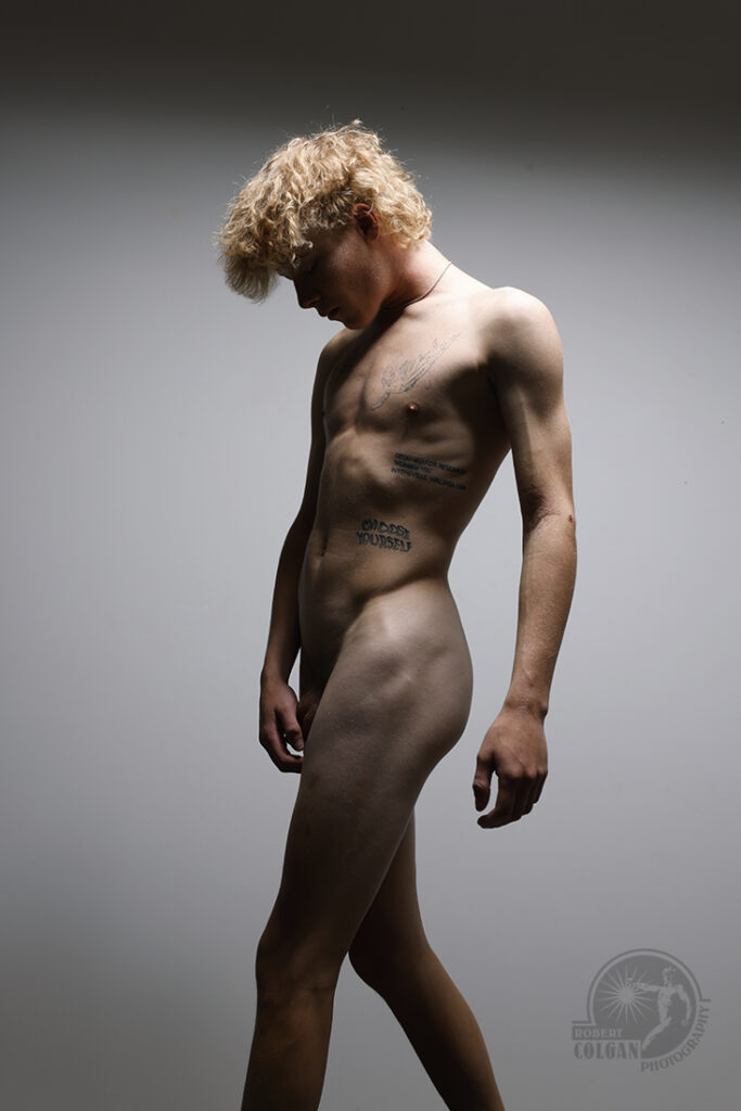 tattooed nude man in studio light