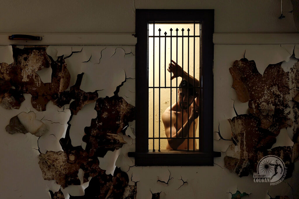 shirtless man grips bars of box office window in old school