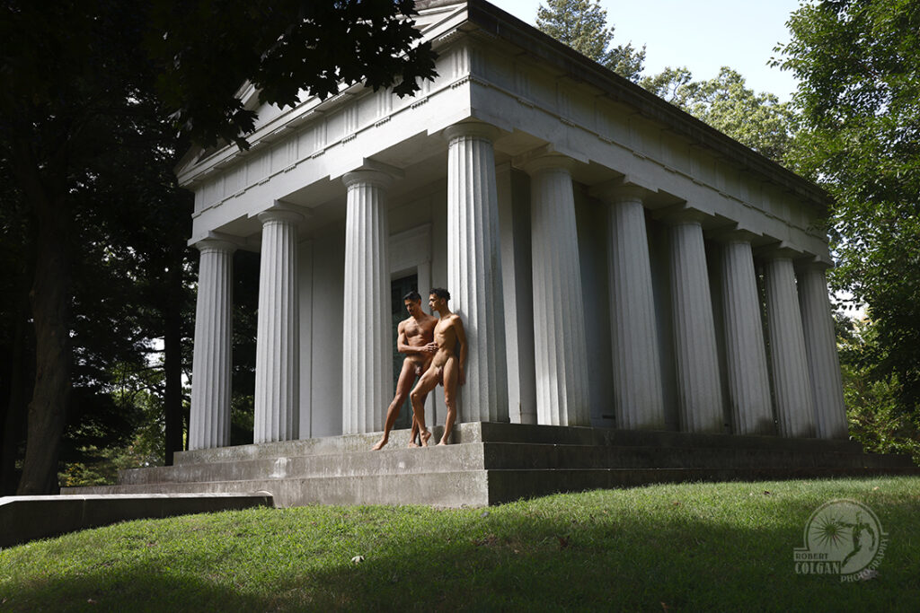 classical view of a temple-like building with two naked men on its steps