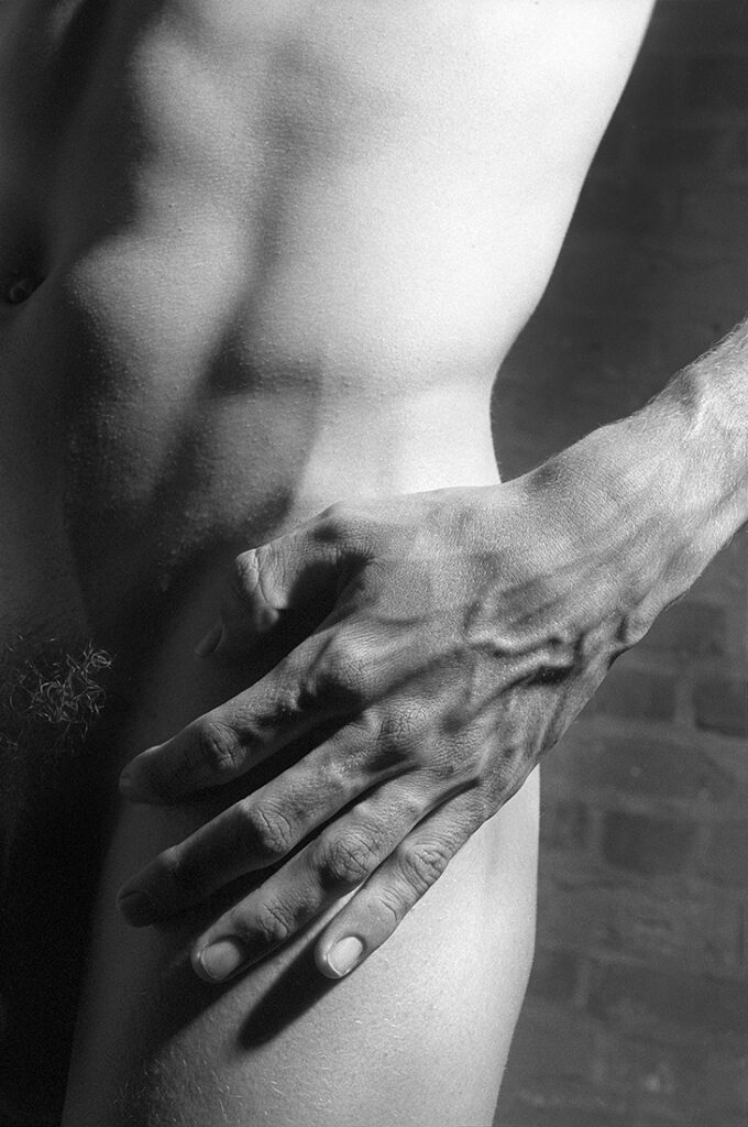 close-up detail of nude with hand on hip