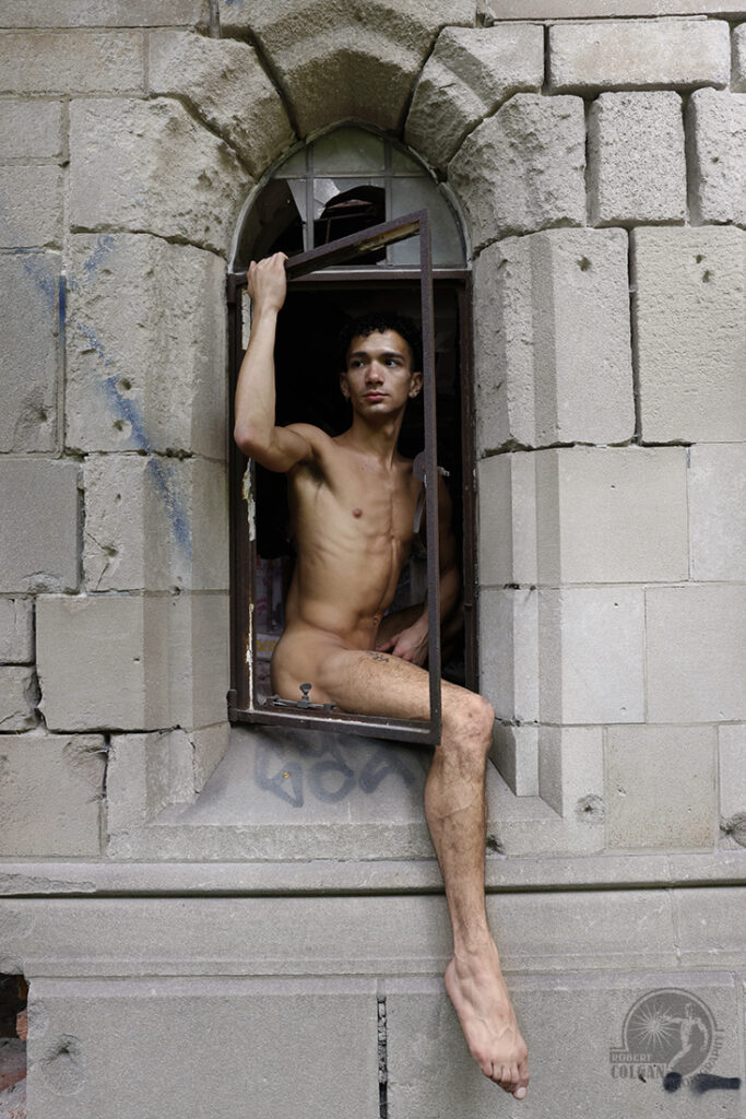 nude male poses in gothic window opening of old church