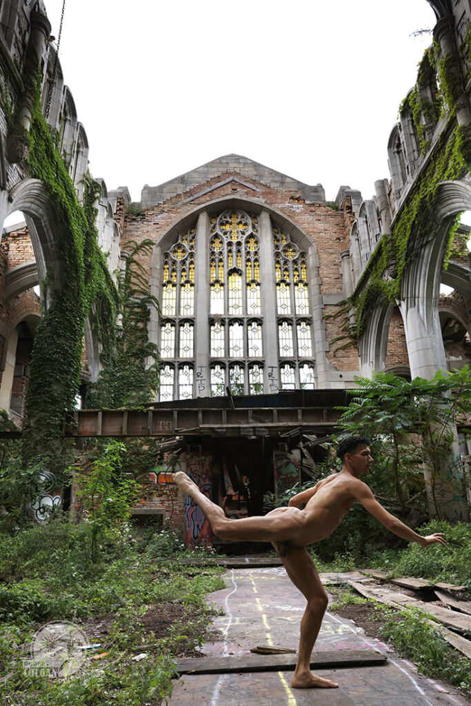 nude man in a fleeting dance pose in ruins of old church