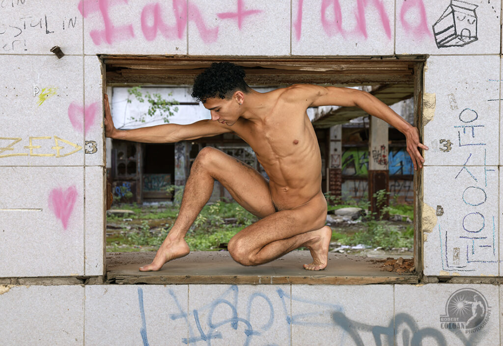 nude man inside a window opening in an old post office with outstretched arms