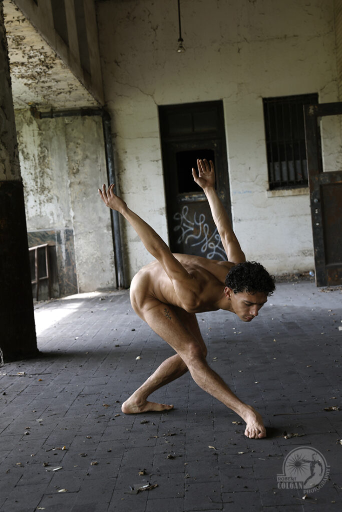 male nude in expressive dance posture on loading dock of old post office