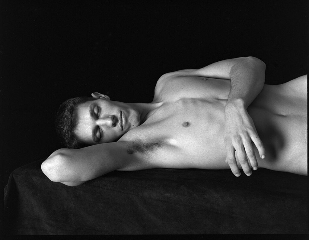 naked man in reclined position with eyes closed