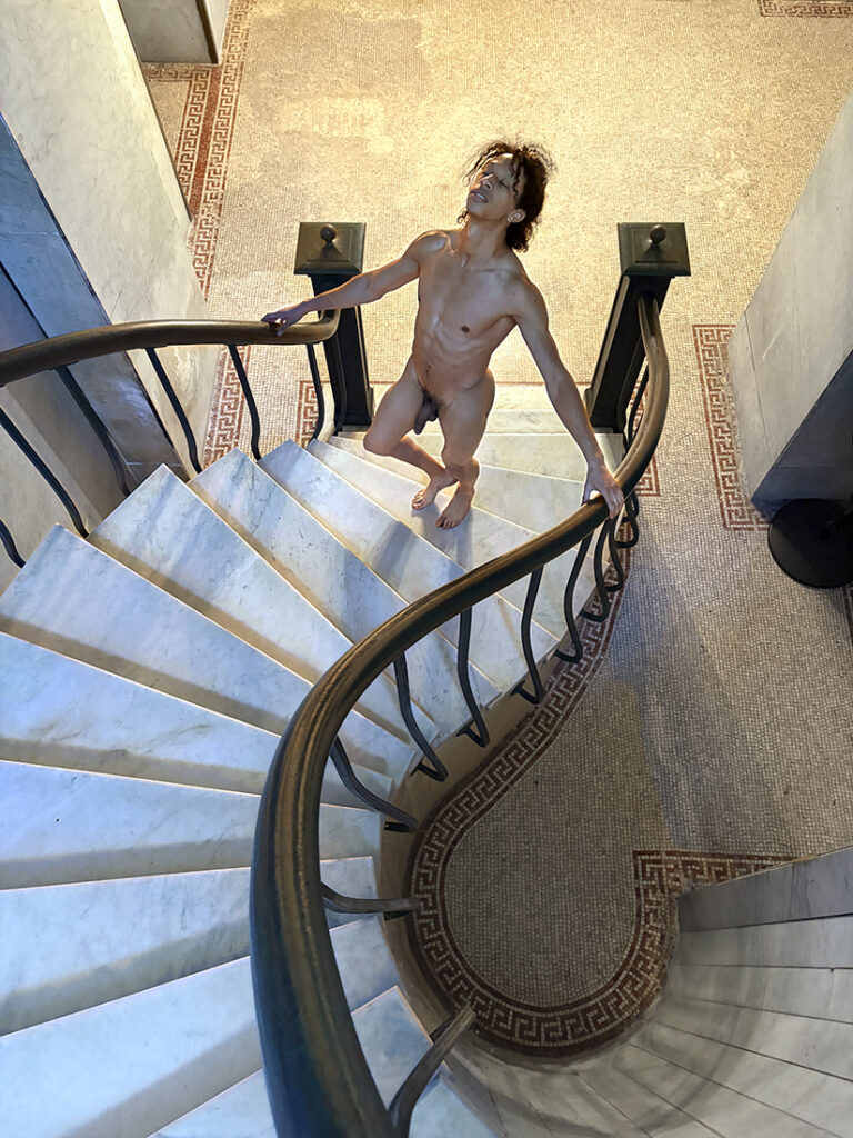 nude man walks up circular stairs with his eyes closed